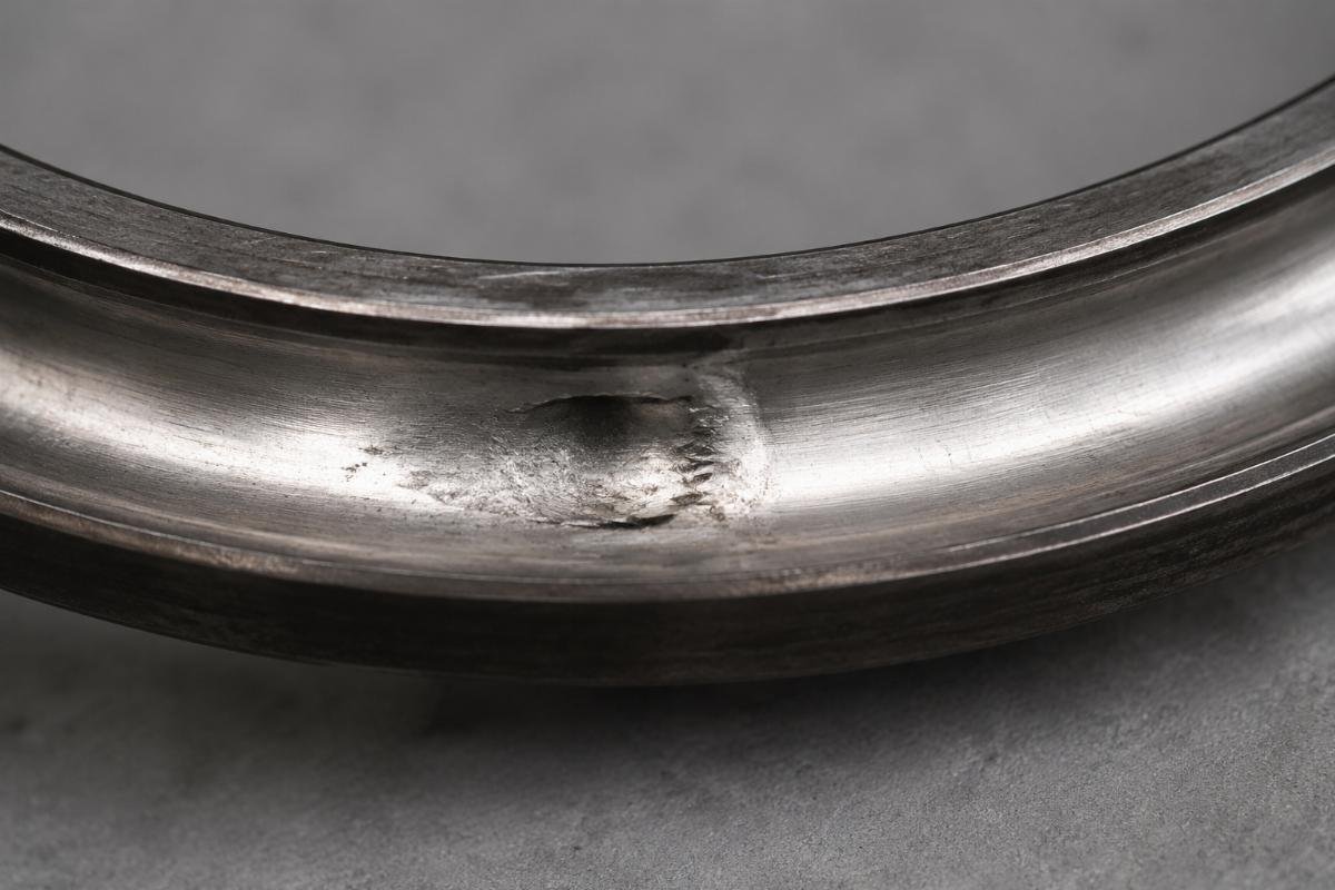 Damaged bearing raceway showing impact indentation marks from improper installation