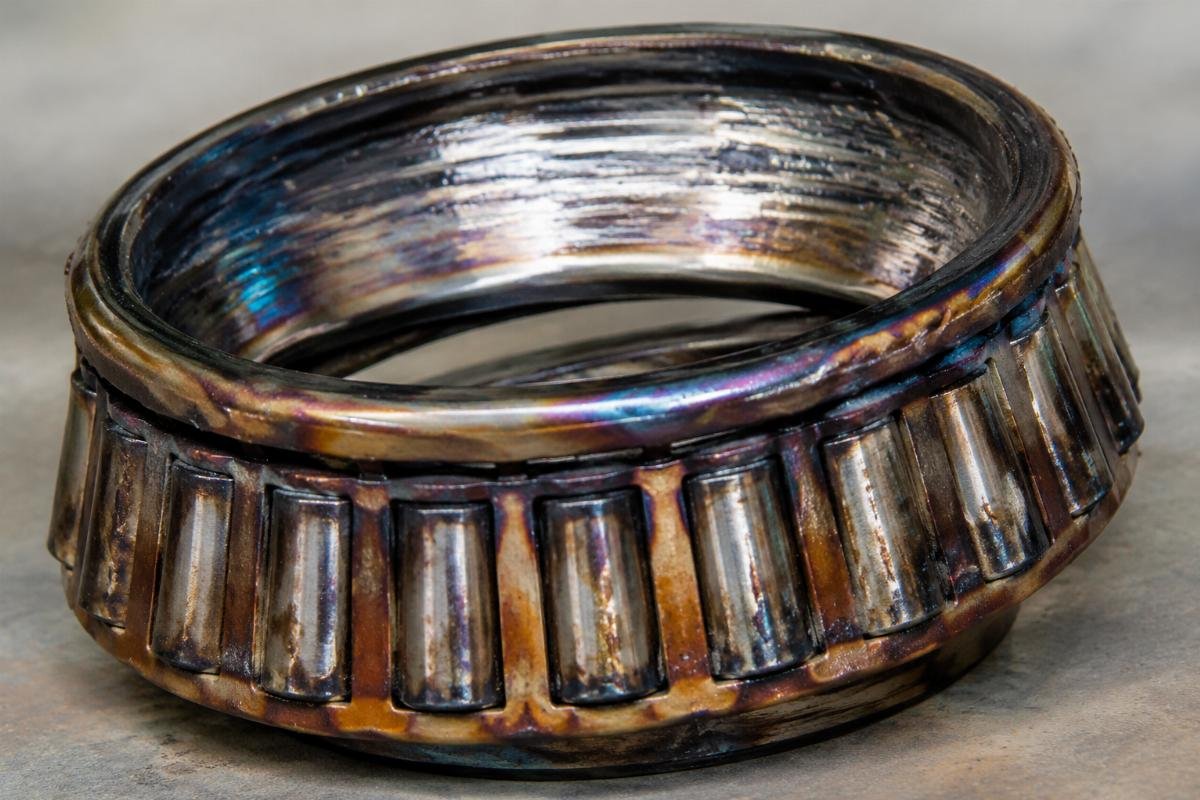 Overheated tapered roller bearing with smeared raceway and discolored cage
